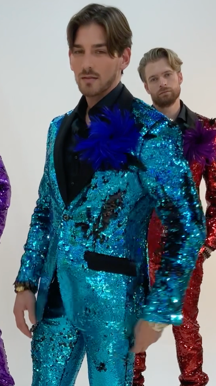 a man wearing a teal Angelino sequin suit the othe man in backround has red sequin suit. Angelino